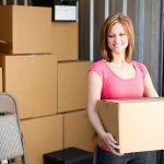 Woman Holding Boxes in front of a Storage Unit