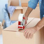 Man Packing Boxes with Packing Tape